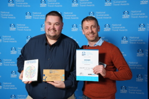 Two men dressed smartly, smiling holding their award certificates